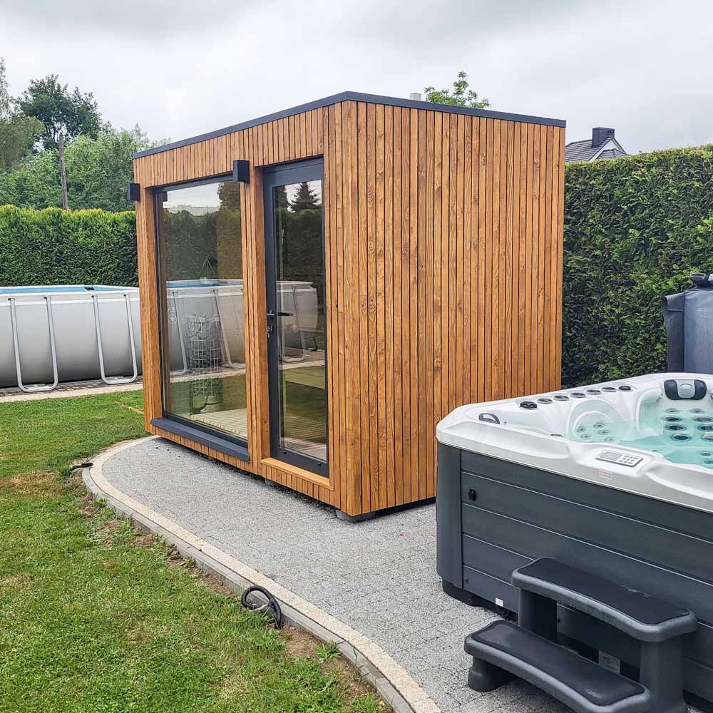 Sauna NATY s dřevěným obkladem, proskleným čelem a vstupem vedle okna