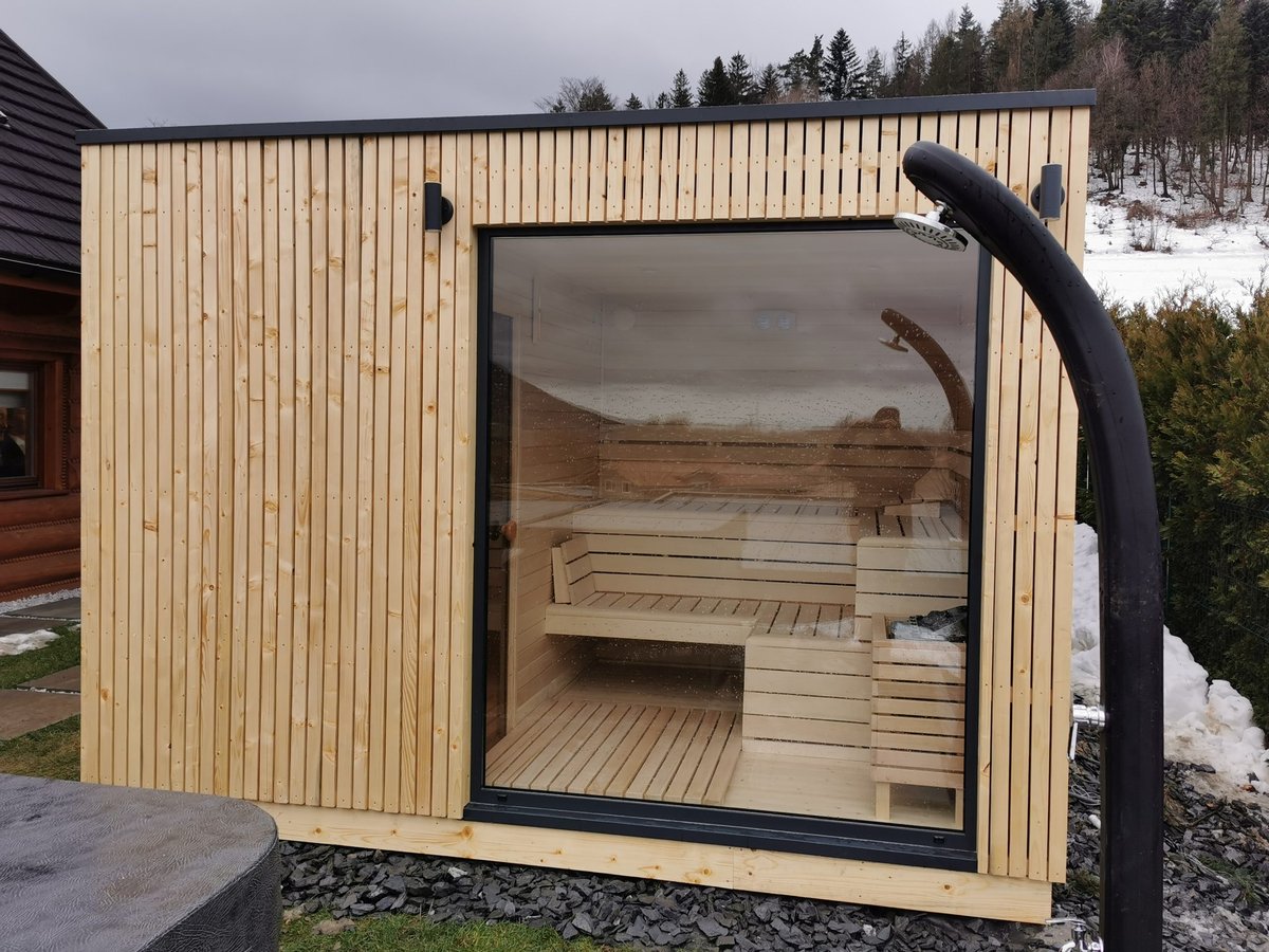 Sauna NIKI se světlým dřevěným obkladem a velkým čelním oknem