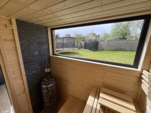 Sauna NERO, realizace: interiér s oknem a kamny
